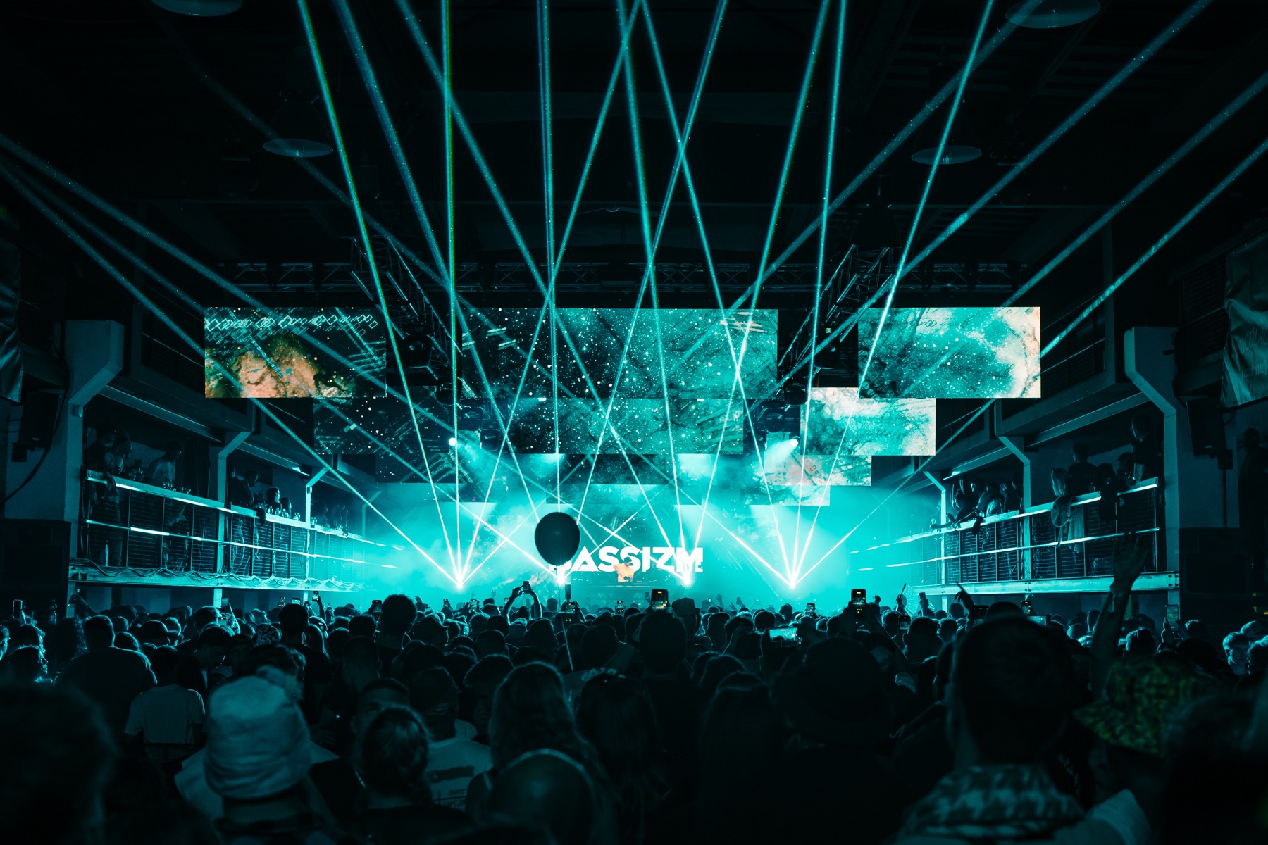 BASSIZM — turquoise lasers illuminating the stage